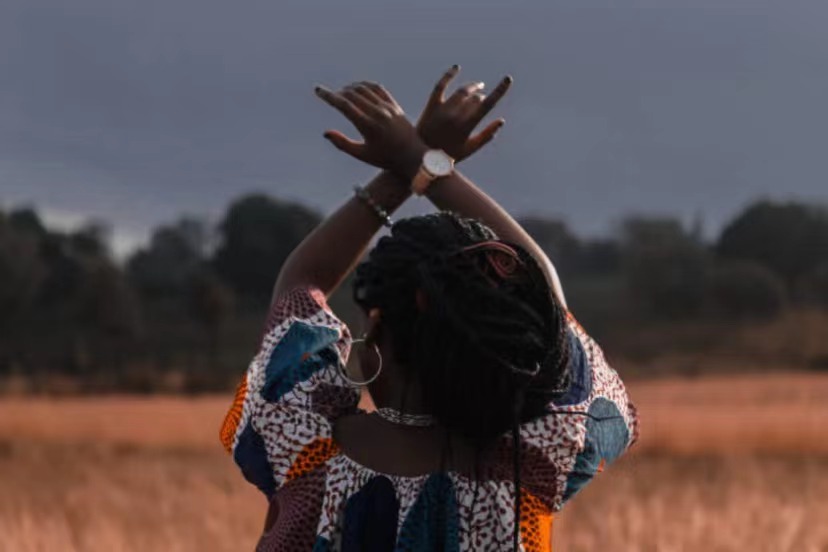Afican woman with hands in the air.