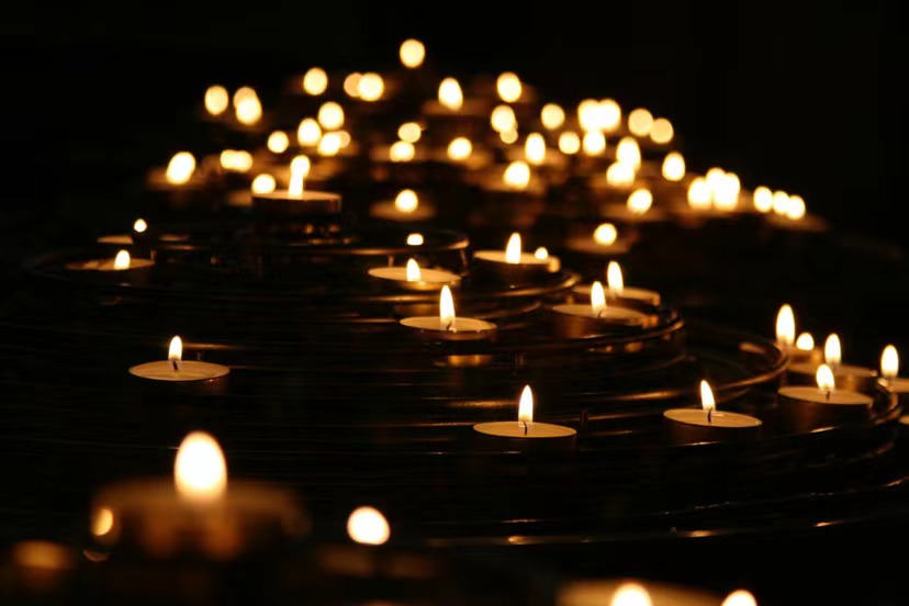 Lit candles in darkness.