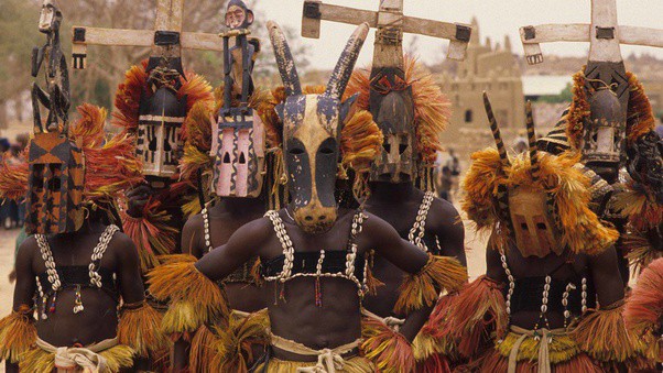 African men dancing with masks on.