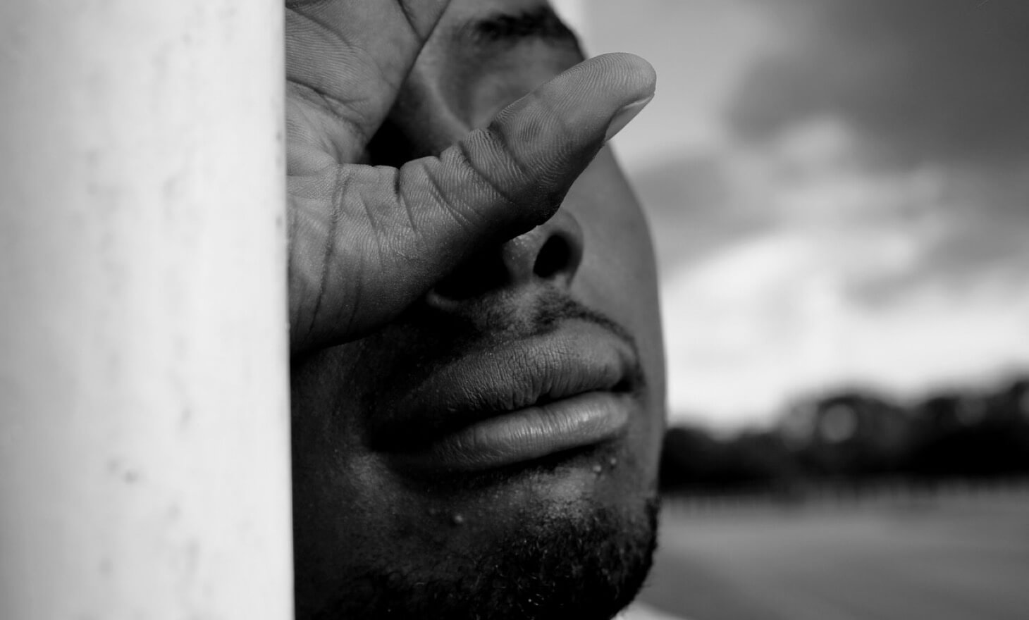 man with hand over his face