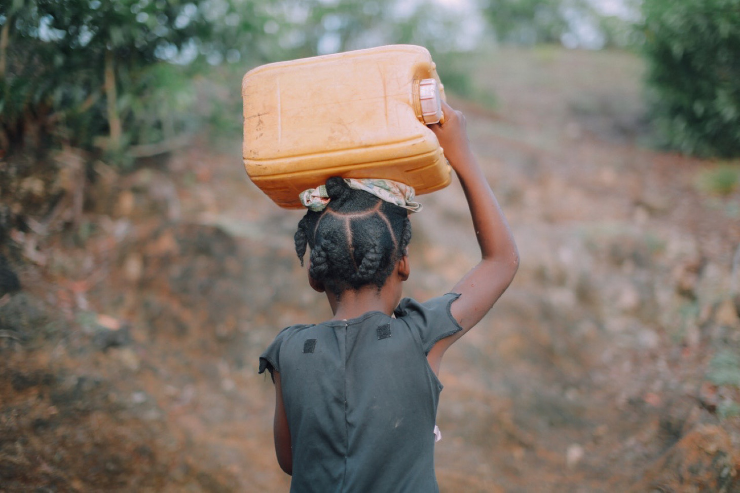 African girl with a jerrycan over her head